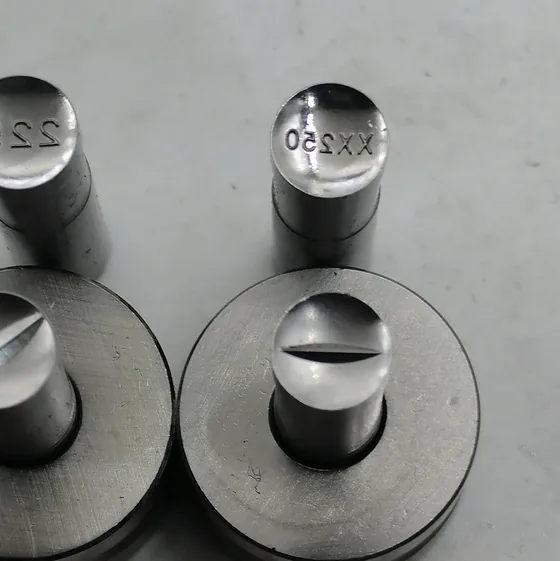 Punch faces engraved with text, next to their dies