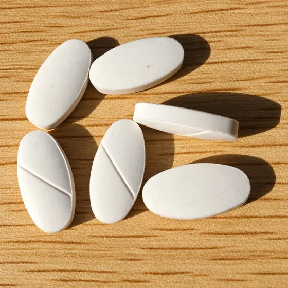 Oval tablets with a score line on a wooden table